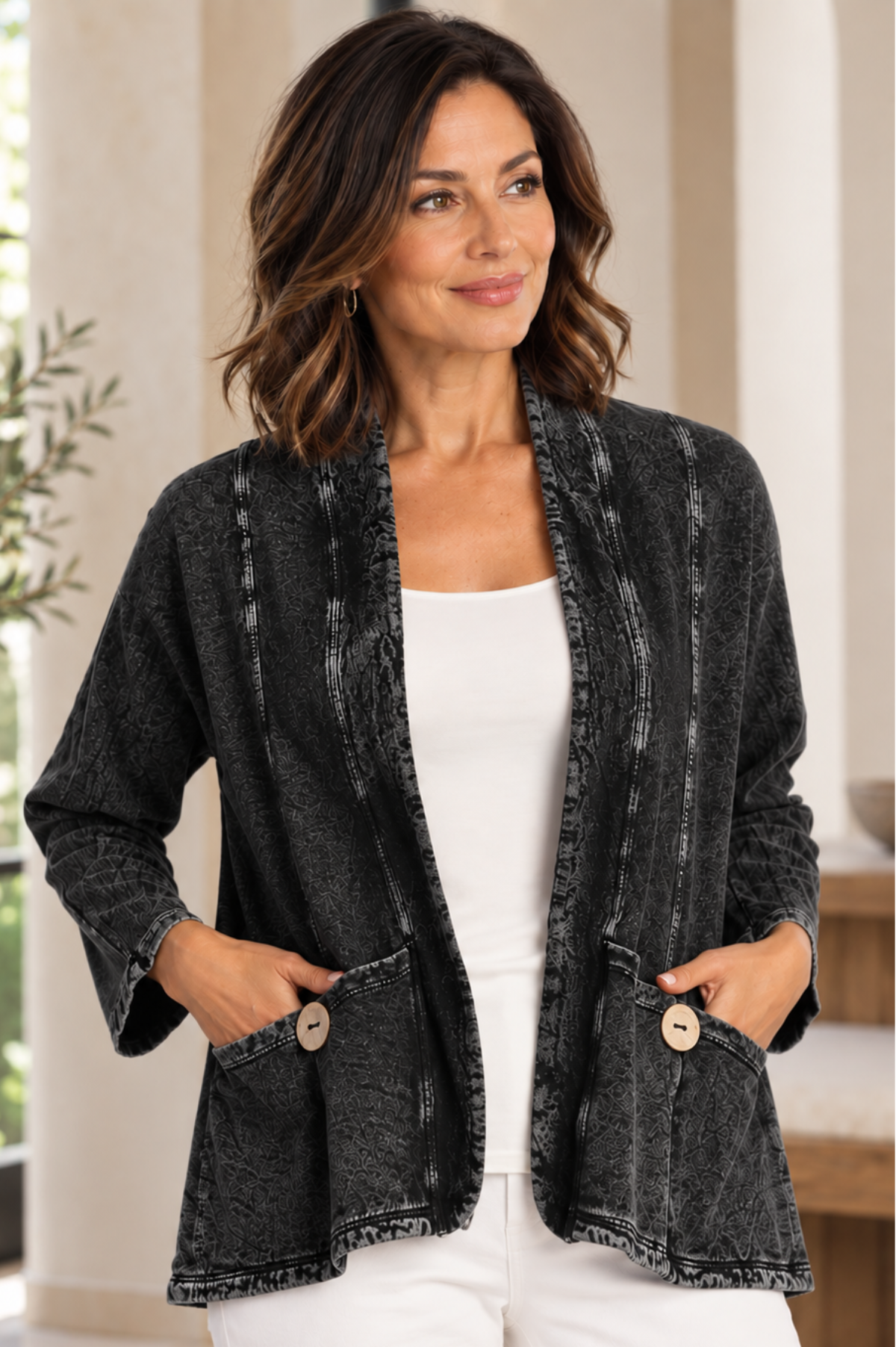 A woman wearing a dark gray mineral-wash open-front cardigan with buttoned front pockets by jess and jane